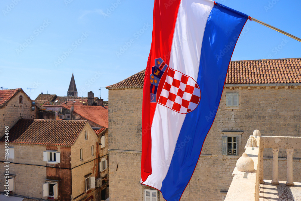 Croatian flag blowing in the wind on the bell tower of The Cathedral of St. Lawrence, landmark in Trogir, Croatia.