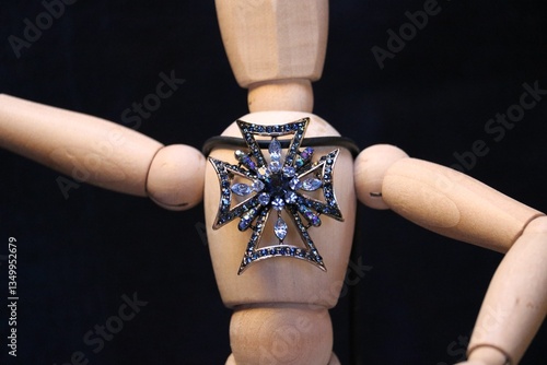 Figure of a wooden man with a brooch with precious stones 