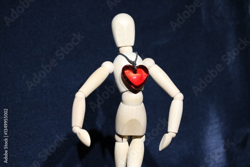 Figure of a wooden toy man with a precious stone in the form of a red heart