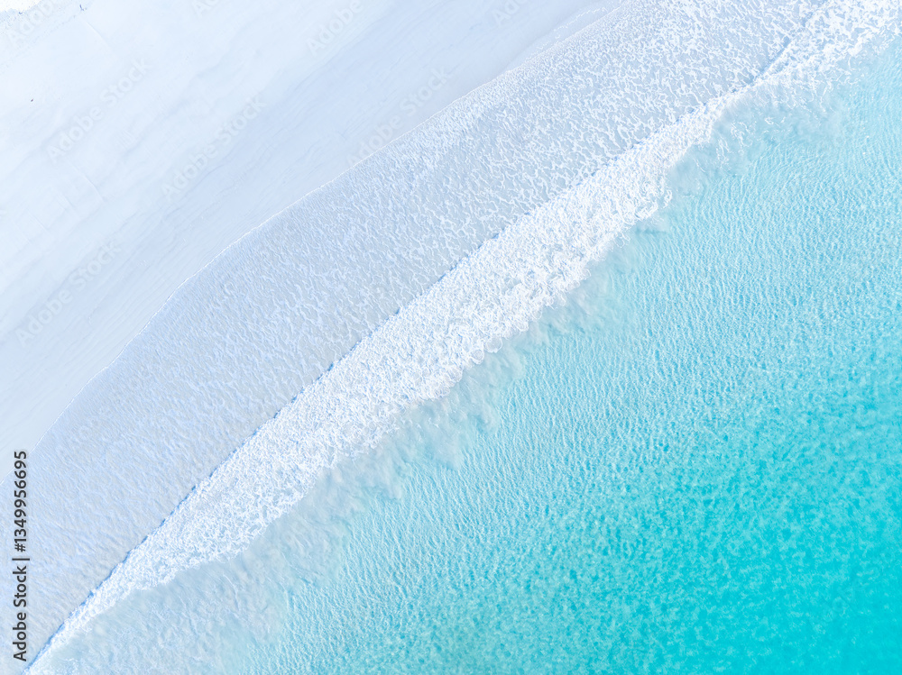 Drone view of white sand beach and azure sea. Water on the sea coast. Summer vacation and holiday. Transparent sea water and waves. Photography for background, postcards, wallpapers.