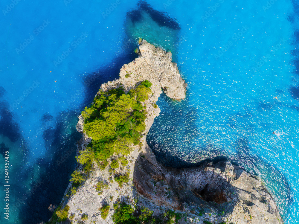 Drone view of the sea coast. Rocky shore and sea water. Vacation and travel. Summer seascape. Aerial view. Transparent sea water and waves. Photography for background, postcards, wallpapers.