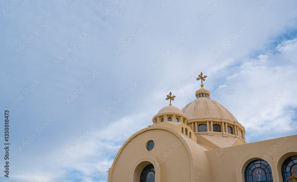 Coptic Orthodox Church in Sharm El Sheikh, Egypt.Against the backdrop of a beautiful sky with clouds. All Saints Church. Concept of the righteous faith