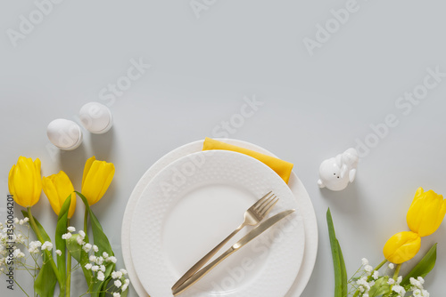Obraz na płótnie Easter frame with pastel yellow eggs, yellow tulips, gypsophila on gray background. View from above. Happy Easter greeting card. w salonie