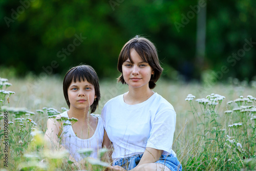 Portrait of sisters spending time together in park in summer