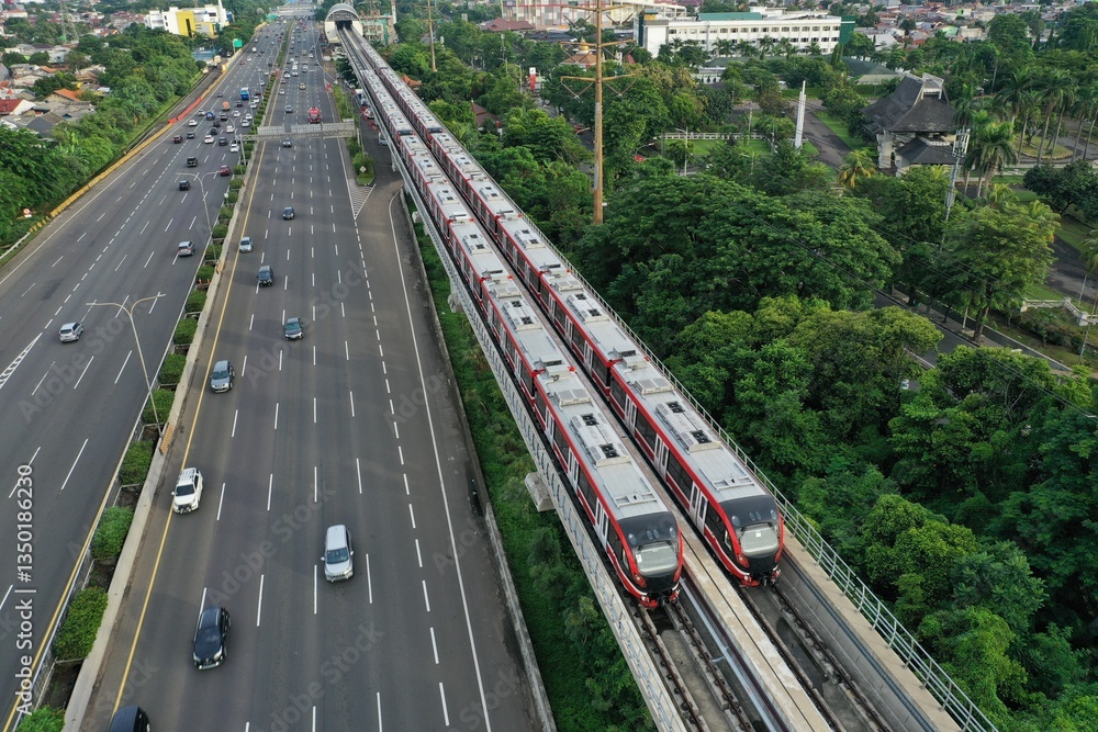 Naklejka premium Aerial view of an LRT train parked adjacent to the toll road