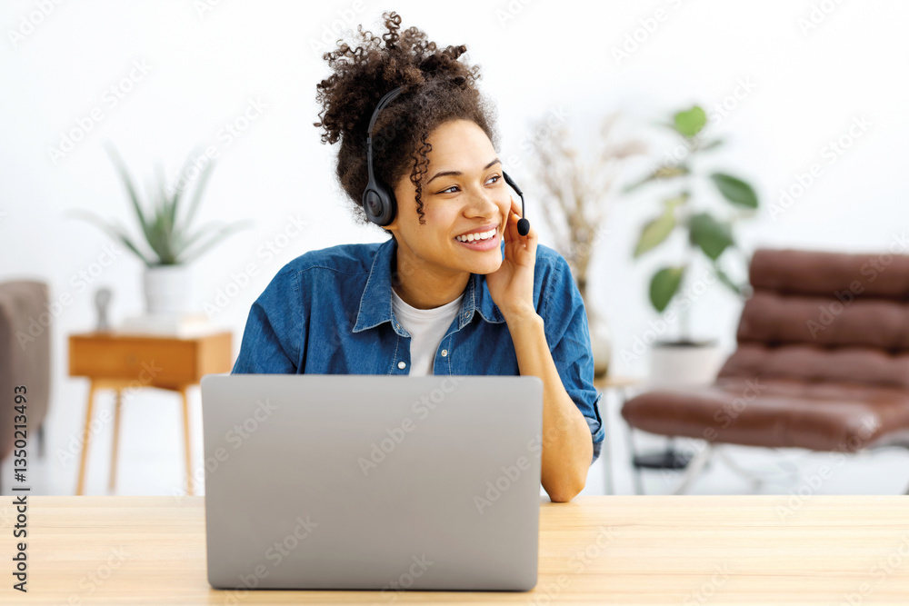 Smiling woman with headset working on laptop