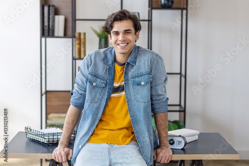 Smiling young man entrepreneur standing in office