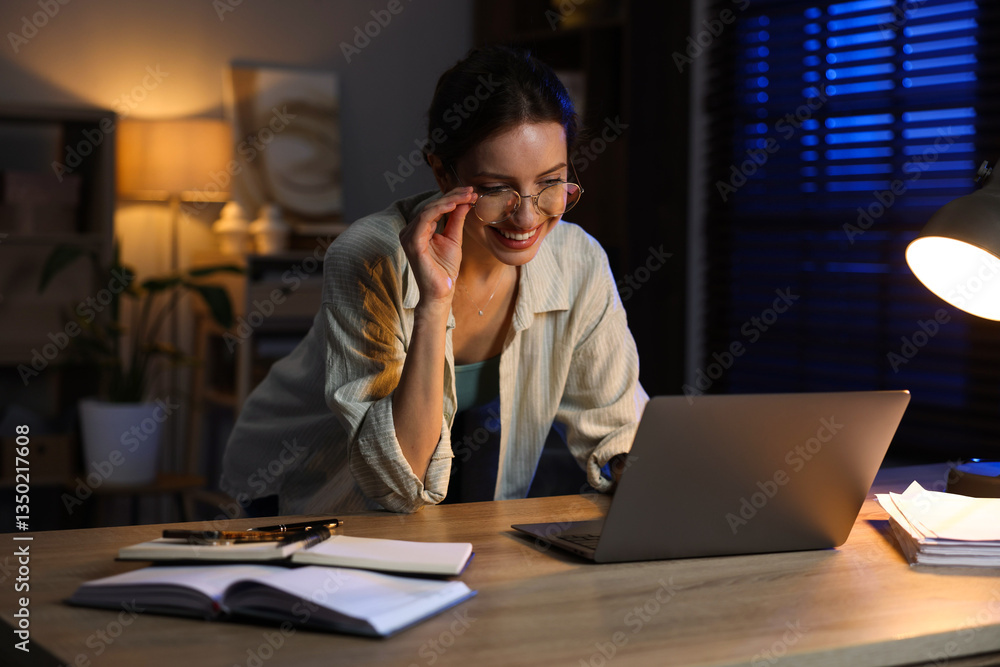 Woman working on laptop at desk in home office Woman working on laptop at desk in home office