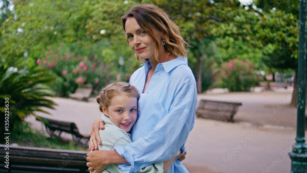 Fototapeta premium Portrait mother daughter together resting green urban park. Girl bonding mommy