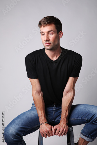Vertical portrait of young handsome man with serious face expression looking away. Mental health.