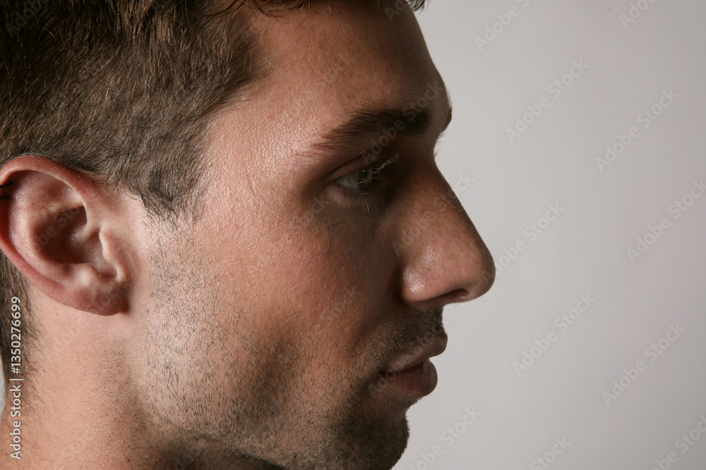 Obraz premium Profile portrait of young handsome man with serious face expression looking at the camera. Mental health.