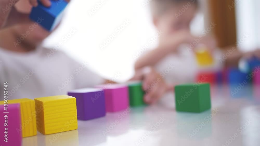A group of lifestyle children are building together. blocks. Play cubes table. concept. Group of children in kindergarten with. cubes. Children in groups building blocks together in a kindergarten. A group of lifestyle children are building together. blocks. Play cubes table. concept. Group of children in kindergarten with. cubes. Children in groups building blocks together in a kindergarten.