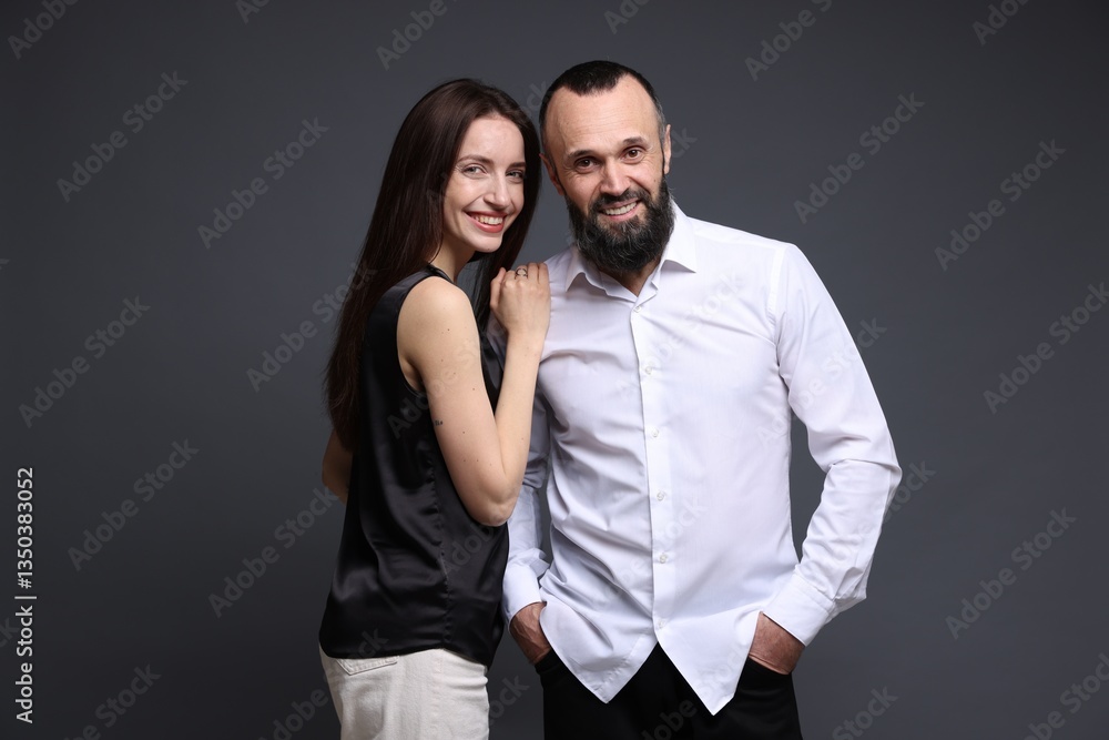 Portrait of happy daughter and father on dark grey background Portrait of happy daughter and father on dark grey background