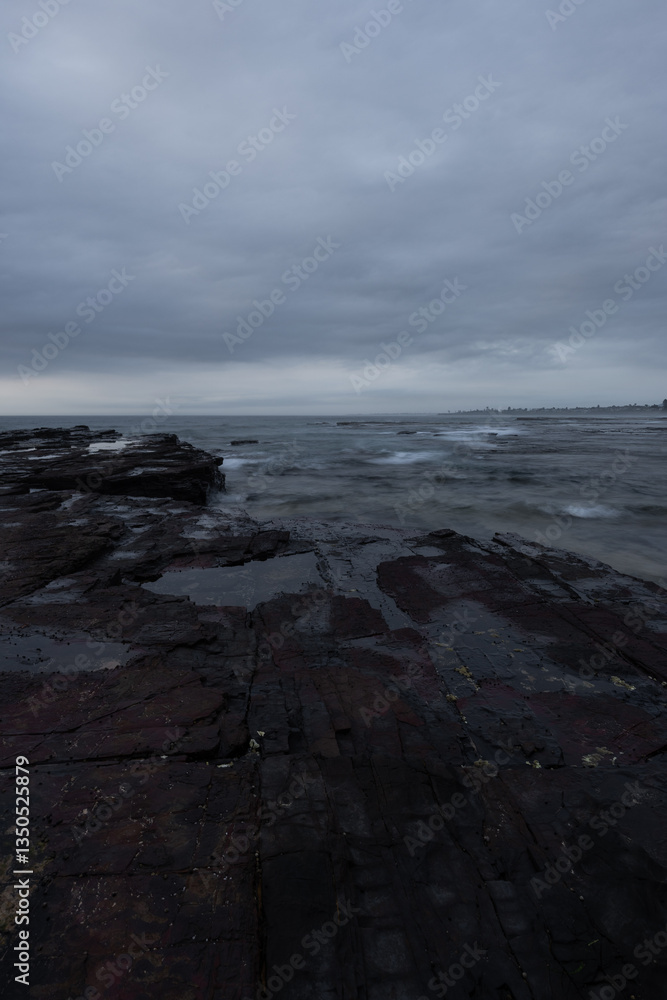 Fototapeta premium Rocky coastline with cloudy sky in the morning.