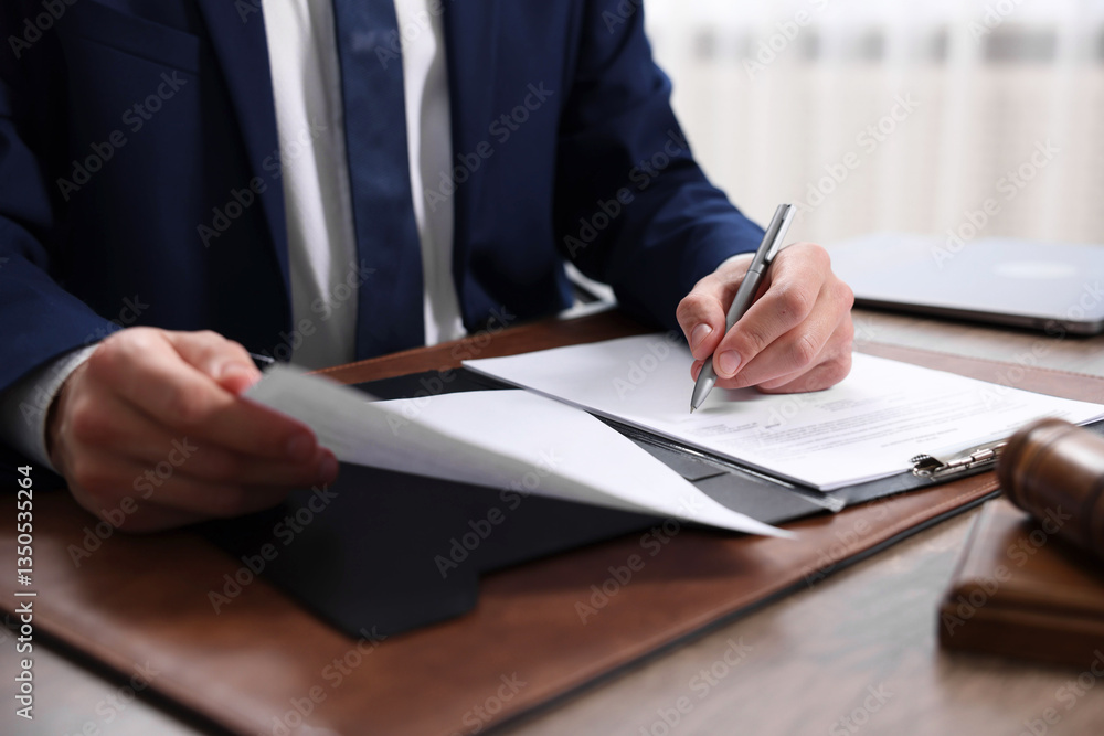 Notary signing document at table in office, closeup Notary signing document at table in office, closeup