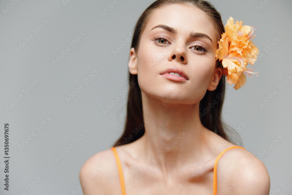 Young woman with a flower, natural beauty, orange dress, serene expression, soft background, perfect for seasonal campaigns, beauty and portrait photography. Young woman with a flower, natural beauty, orange dress, serene expression, soft background, perfect for seasonal campaigns, beauty and portrait photography.