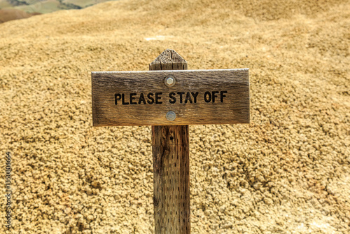 North America, United States, Oregon, Central Oregon, Redmond, Bend, Mitchell. Series of low clay hills striped in colorful bands of minerals, ash and clay deposits. Mounds. sign.