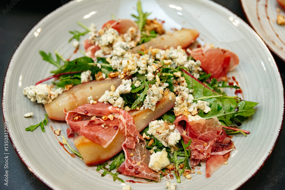 Gourmet arugula salad with poached pears and blue cheese.
