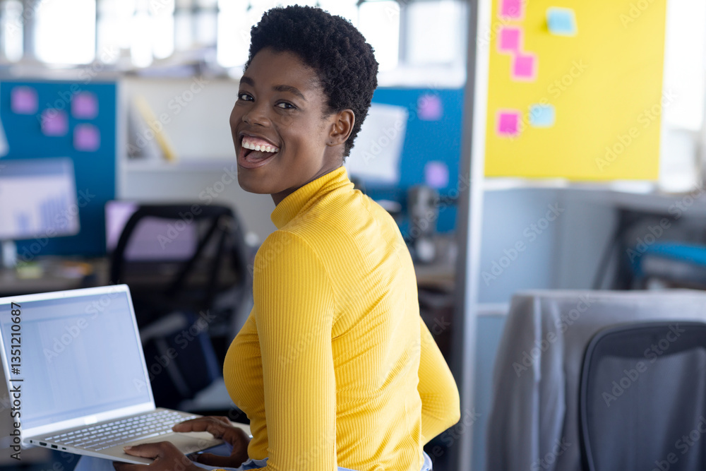 Smiling woman in yellow sweater using laptop at modern office workspace Smiling woman in yellow sweater using laptop at modern office workspace