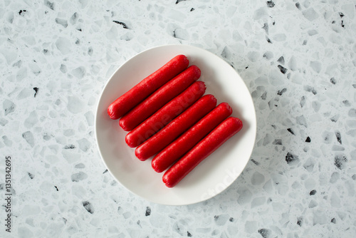 Foto A top down view of red hot dogs, on a plate.