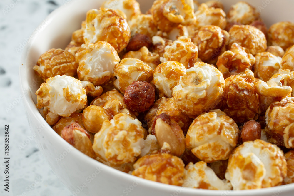 A closeup view of a bowl of caramel coated popcorn snack. A closeup view of a bowl of caramel coated popcorn snack.