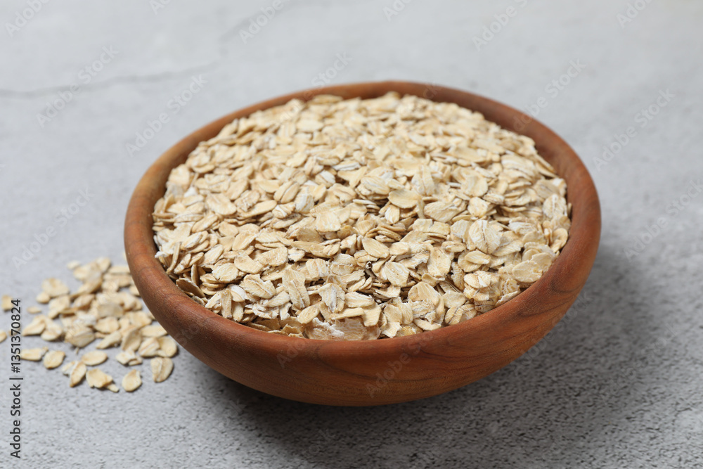 Composition with oatmeal flakes on gray background. Cooking breakfast Composition with oatmeal flakes on gray background. Cooking breakfast