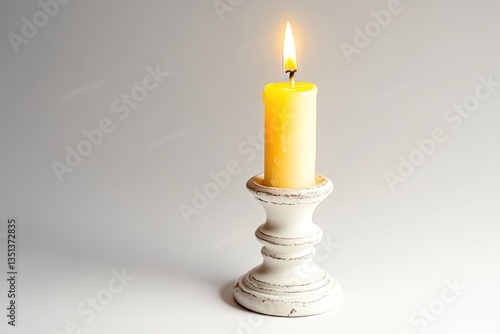 A single lit candle on a white table with a minimalist background