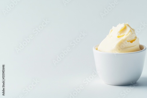 single smooth white ceramic bowl brimful of creamy freshly churned dairy butter sits atop seamless white background