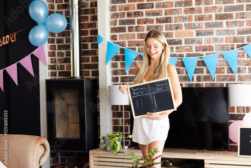 Baby shower, Woman holding chalkboard at gender reveal party, smiling with excitement