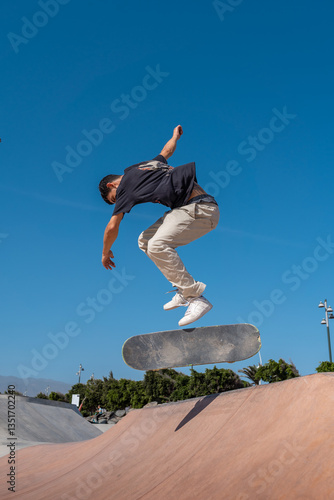 young skater wearing black tshirt skating  in a skate park in a sunny day
