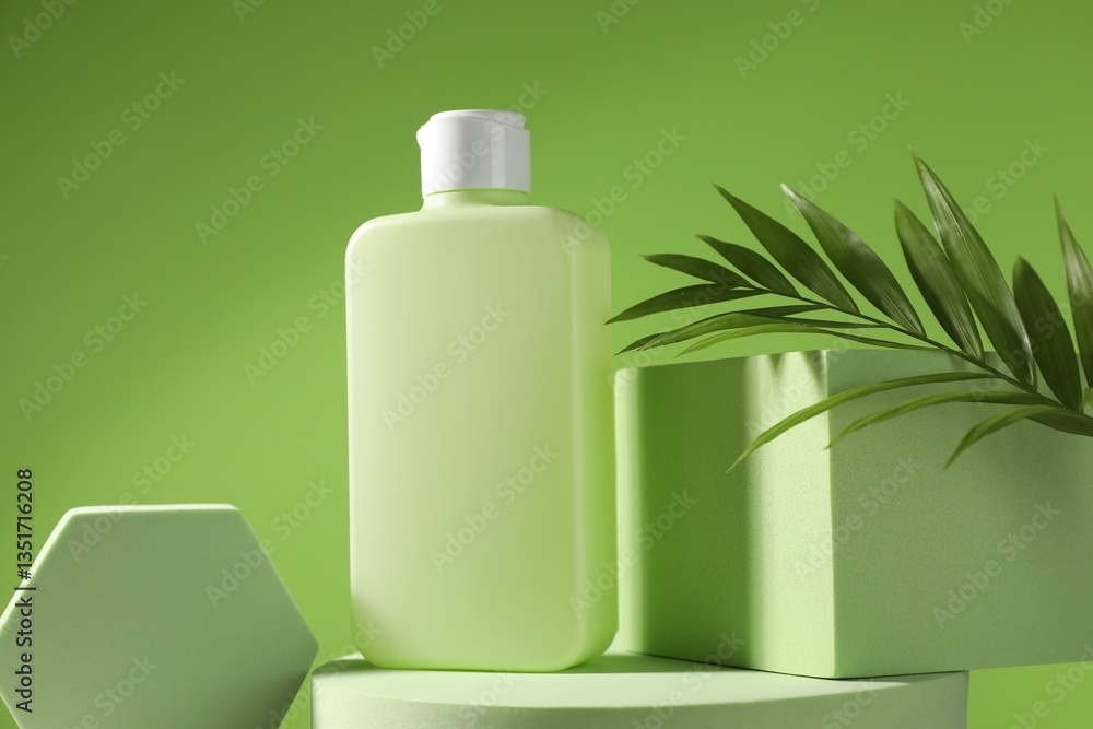 Bottle of sun protection product, branch and podiums against green background Bottle of sun protection product, branch and podiums against green background