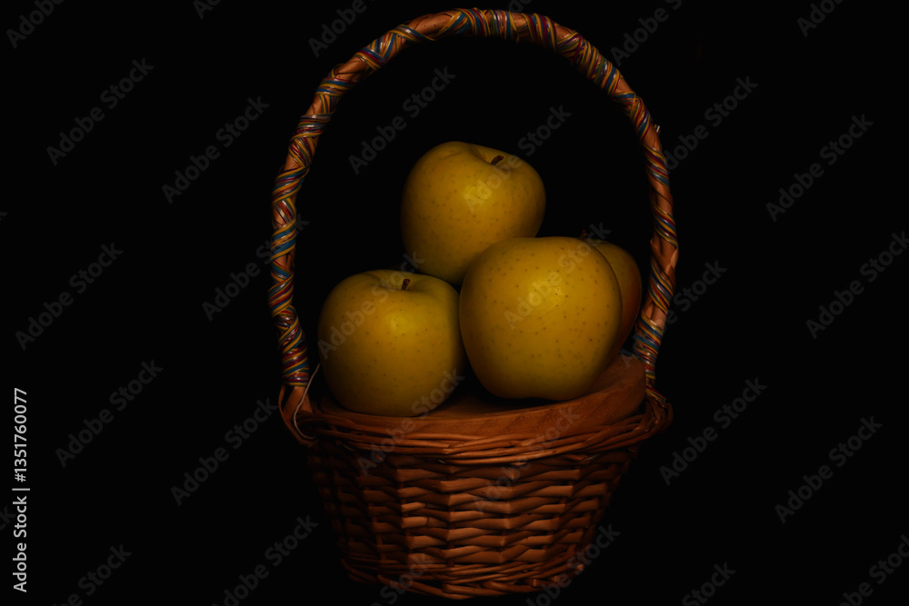 Basket of fruit (apples), taken with a dominance of lateral light that accentuates the shadows in an effect similar to chiaroscuro Basket of fruit (apples), taken with a dominance of lateral light that accentuates the shadows in an effect similar to chiaroscuro