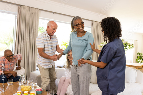 Senior diverse friends interacting warmly in supportive group activity at home, smiling together