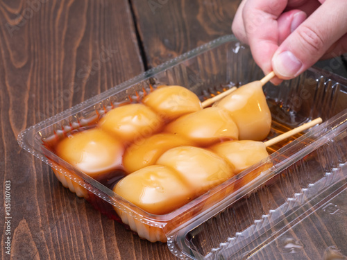 Obraz na płótnie プラスチック容器に入っている和菓子。甘い醤油タレの