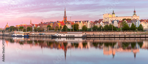 Obraz na płótnie Oder River waterfront in Szczecin Poland with illuminated buildings and docked boats before sunrise w salonie