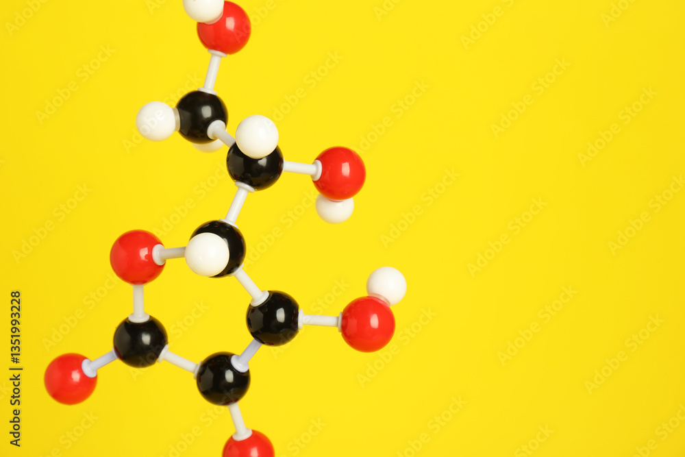 Obraz premium Molecule of vitamin C on yellow background, closeup and space for text. Chemical model