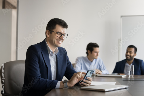 Wallpaper Mural Smiling mature 45s businessman in suit sit at desk using smartphone, check updates, using new AI business tools or platform, check messages, exchanges sms by work related matters. Wireless tech usage Torontodigital.ca