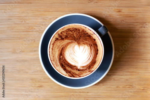 Top view of hot latte coffee with latte art in the gray cup on wooden table,close up cup of coffee