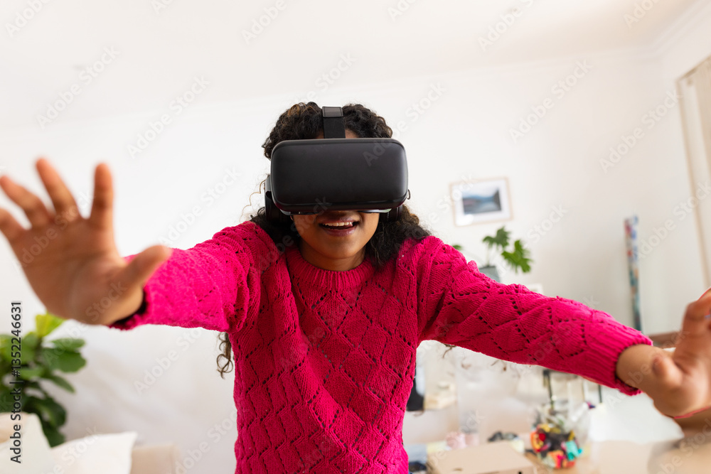 Teenager wearing VR headset at home, reaching out and enjoying virtual experience Teenager wearing VR headset at home, reaching out and enjoying virtual experience