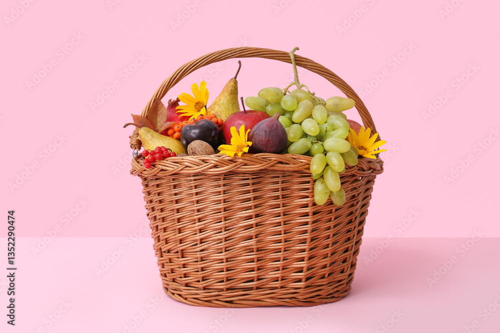 Wicker basket with different fresh fruits on pink background Wicker basket with different fresh fruits on pink background