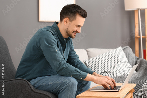 Handsome man using laptop i...