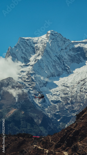 Helicopter flying near snow-covered mountain