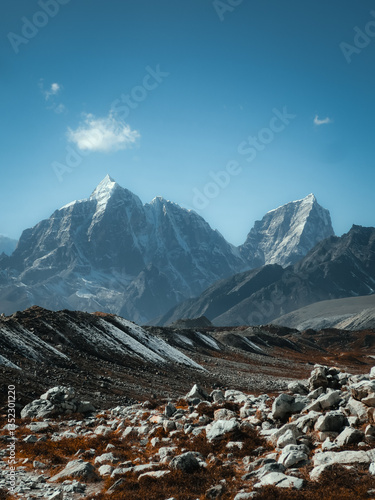 Rocky foreground and mountain peaks under clear sky