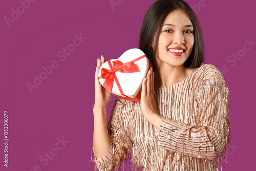 Smiling young woman holding...