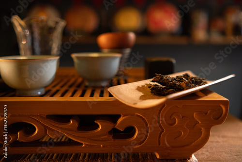 Close view of the wooden table with traditional chinese tea ceremony accesories and cups of tea. Wooden tray with tea leaves