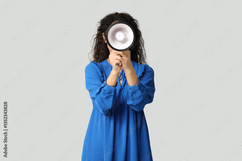 Obraz premium Young African-American woman with megaphone on light background