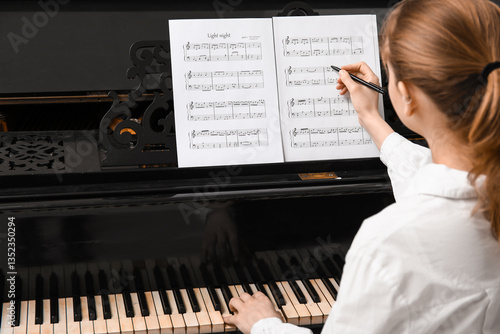 Woman playing piano and wri...