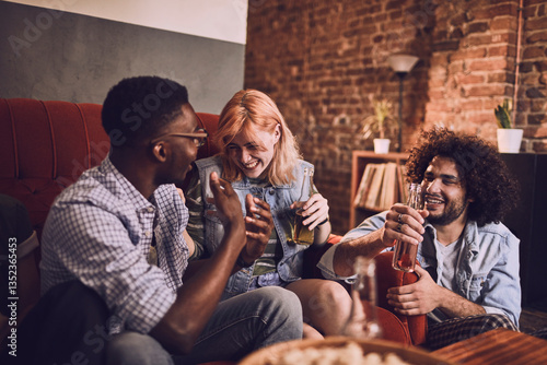 Young group of people having fun on a couch while drinking beer