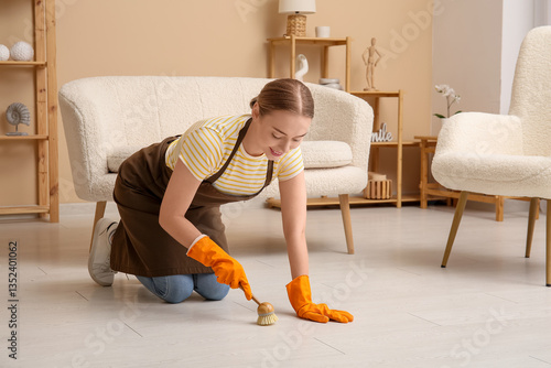 Young woman cleaning floor ...