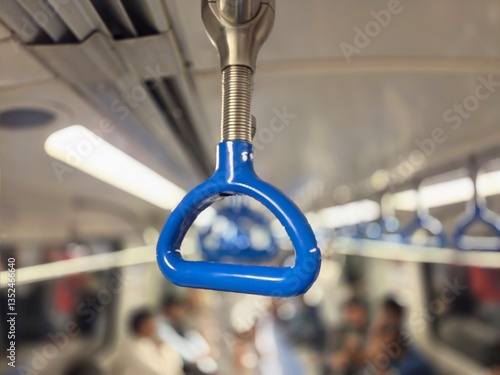 A close-up photograph depicts a subway train's handlebar, with a softly blurred background highlighting the busy atmosphere of a crowded train car during the daily commuters.